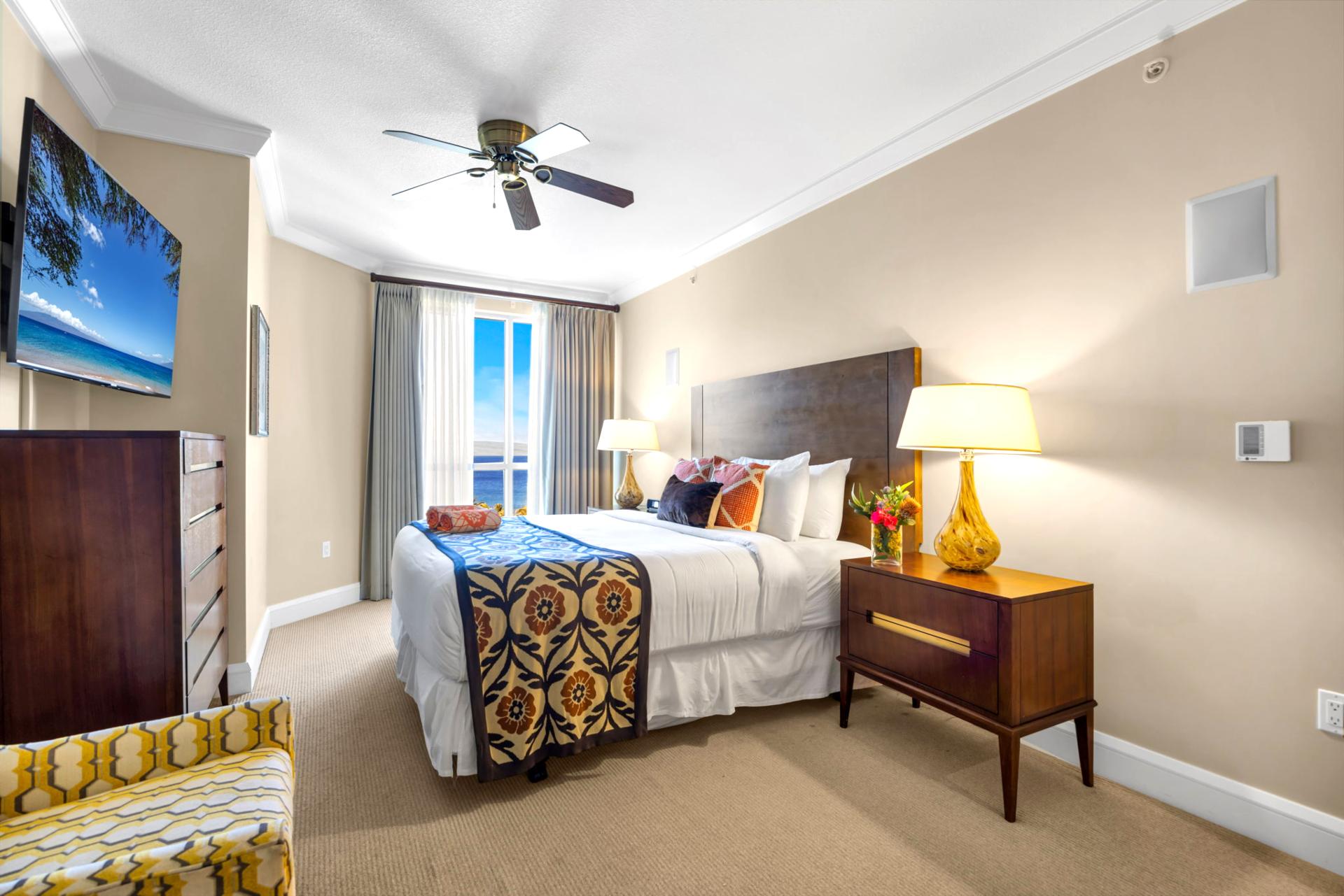 King guest bedroom with ceiling fan and view window for cool island breezes.