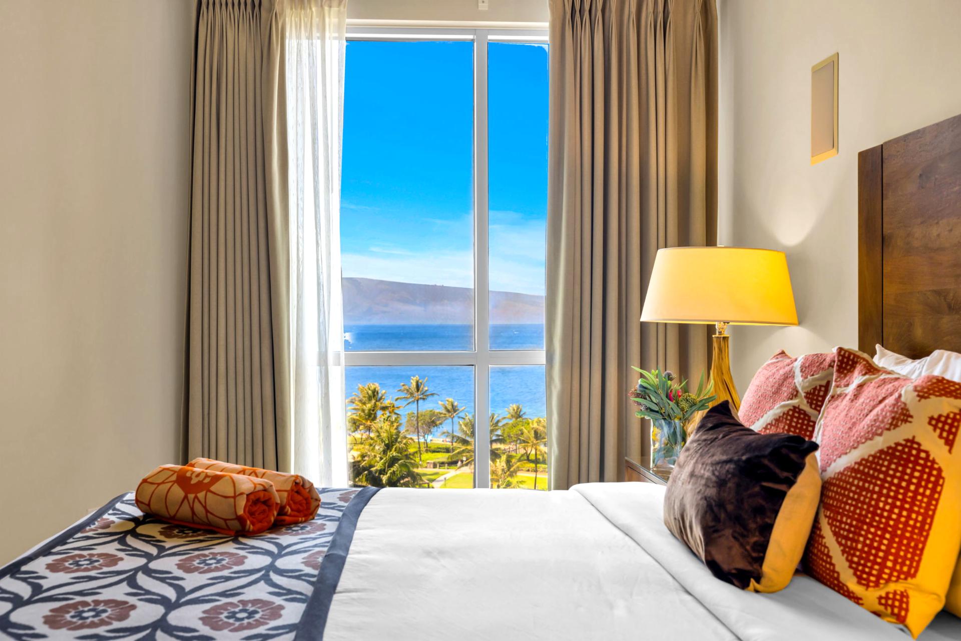 Guest bedroom with ocean views and direct balcony access for easy indoor-outdoor living.