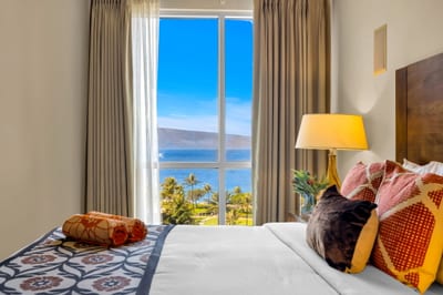 Guest bedroom with ocean views and direct balcony access for easy indoor-outdoor living. HKK-825