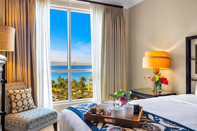 King primary suite with ocean glimpses and ensuite access for added comfort.