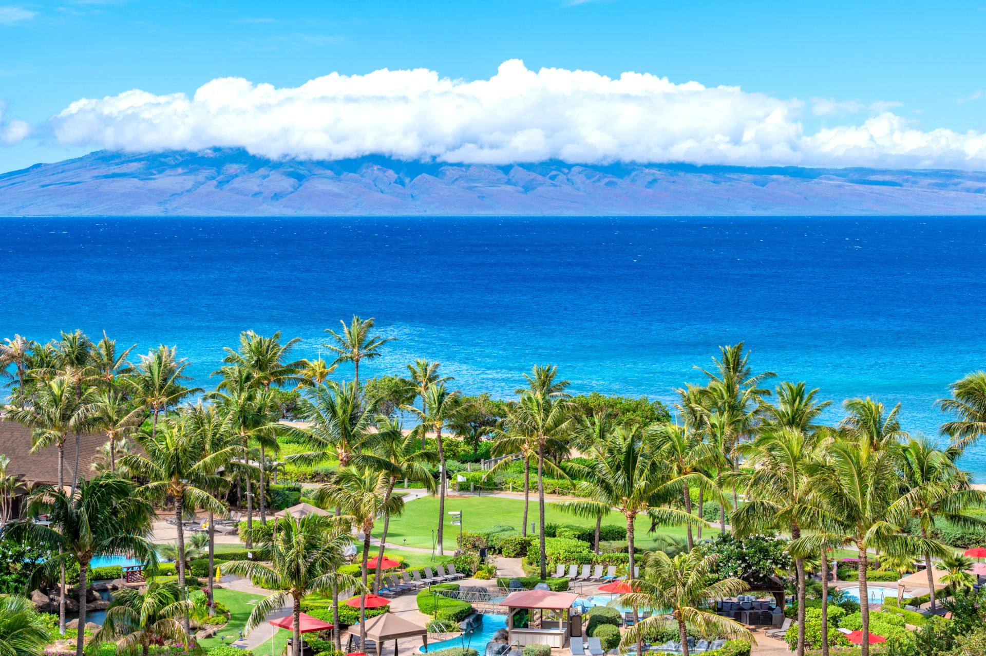 Unmatched ocean views and lush resort landscaping define the Honua Kai experience, with the island of Molokai rising across the vibrant blue channel.