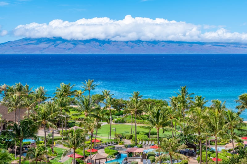 Unmatched ocean views and lush resort landscaping define the Honua Kai experience, with the island of Molokai rising across the vibrant blue channel. HKK-829