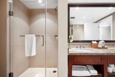 Bright walk-in shower with elegant vanity and soft lighting charm.