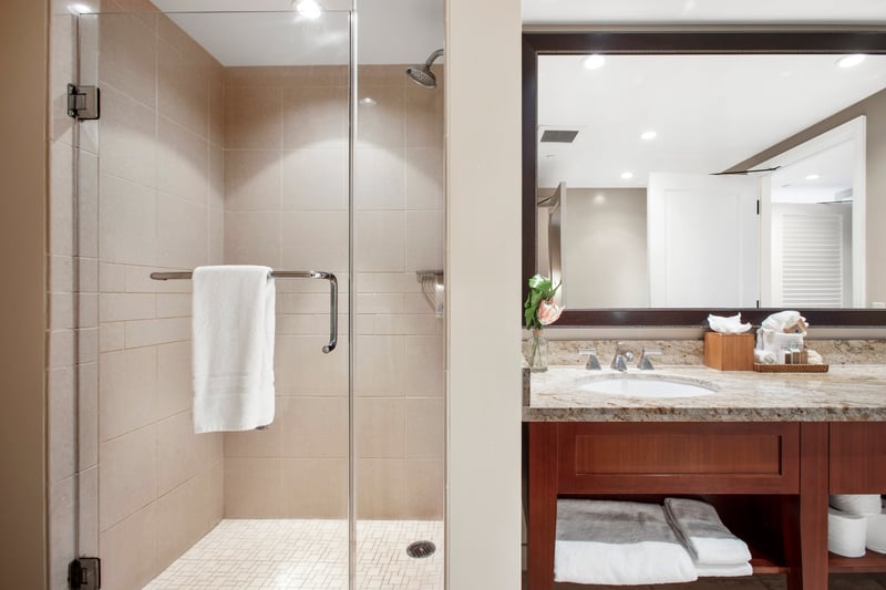 Bright walk-in shower with elegant vanity and soft lighting charm.