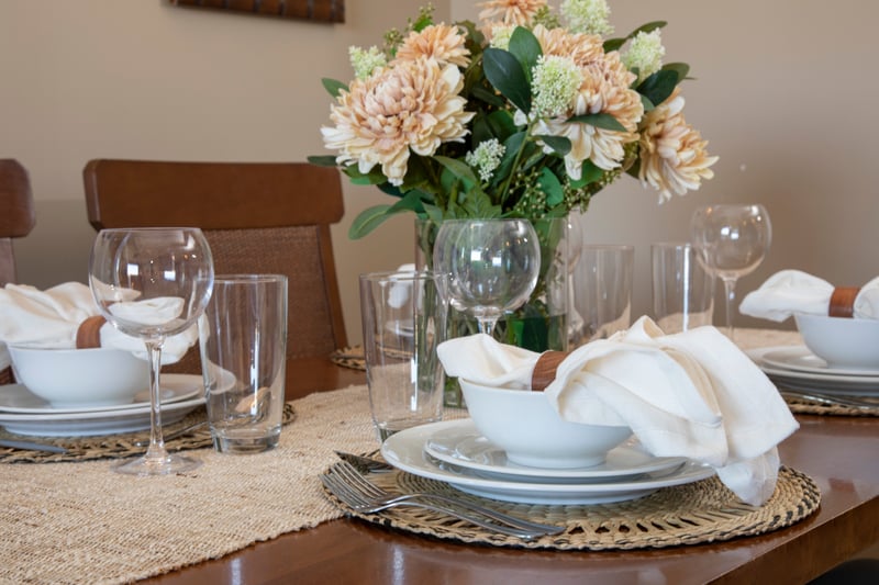Elegant dining table set with florals, glassware, and woven accents. HKK-920