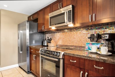 Warm-toned kitchen with modern appliances and tropical coffee station setup.