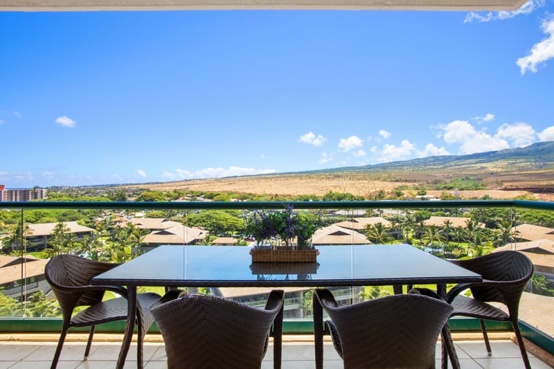 Balcony dining with panoramic mountain views and tropical rooftop scenery.