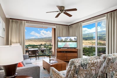 Cozy living room with balcony and breathtaking mountain view backdrop.