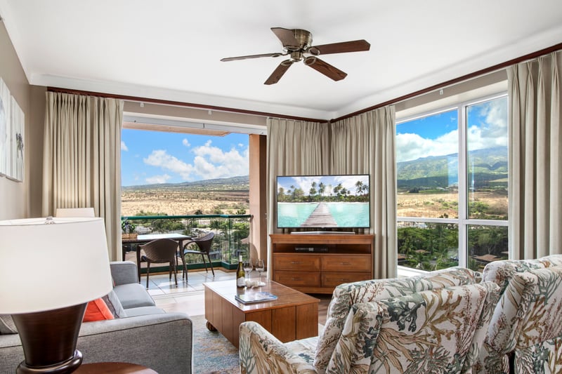 Cozy living room with balcony and breathtaking mountain view backdrop.