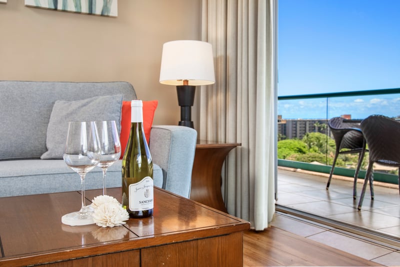 Cozy indoor wine setup with tropical balcony and skyline backdrop. HKK-920