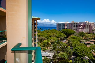 Private lanai with lush garden views and sparkling ocean backdrop.