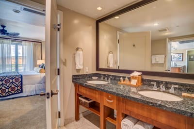 Spacious ensuite bathroom with dual sinks and elegant granite countertop.