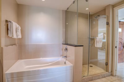 Luxurious bathroom with soaking tub and sleek glass-enclosed walk-in shower.
