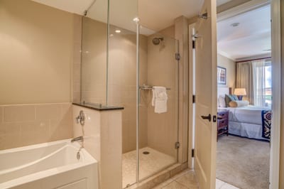 Spacious ensuite bathroom with glass shower and deep soaking tub.