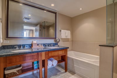 Luxurious bathroom with dual sinks, soaking tub, and granite vanity.