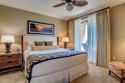 Tropical-inspired bedroom with sunset artwork and private balcony access.