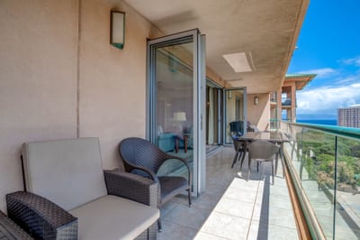 Spacious balcony with ocean views and cozy outdoor seating arrangement.