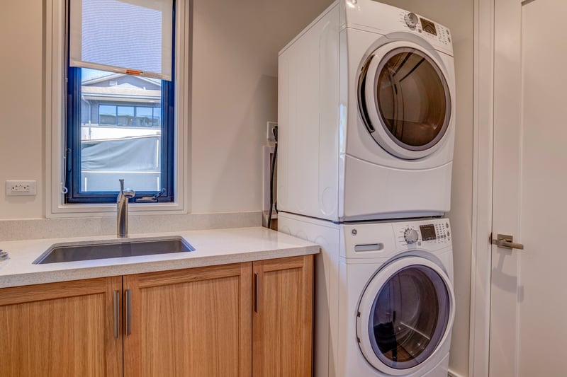 Laundry room featuring stacked washer dryer for easy beach clean up
