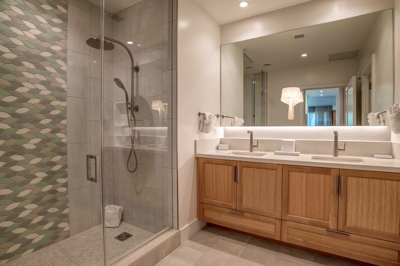 Elevate guest stays with a modern bathroom featuring dual sinks and a walk-in shower