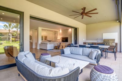 Relax under the covered lanai with outdoor sofa, coffee table, and peaceful island scenery