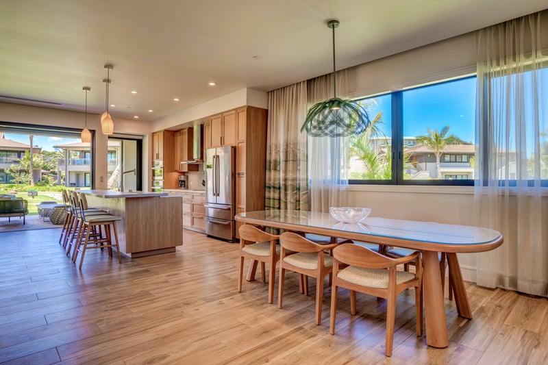 Modern kitchen with oversized island, warm wood cabinets and stunning indoor-outdoor flow