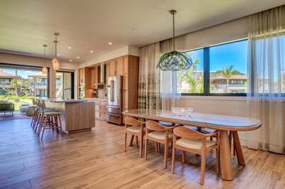 Modern kitchen with oversized island, warm wood cabinets and stunning indoor-outdoor flow