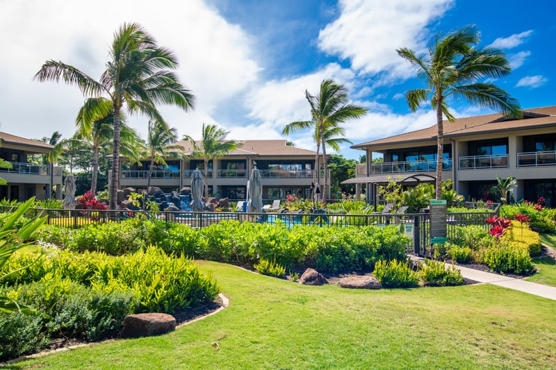 Inviting resort grounds with lush tropical landscaping, swaying palms and vibrant gardens