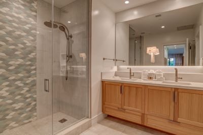 Walk-in glass shower with spa-style dual vanities for a luxury guest experience