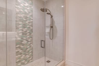 Luxury walk-in shower with full glass enclosure, modern tile work and designer fixtures