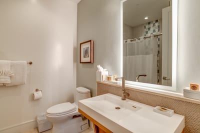 Upgraded bathroom with backlit mirror and modern fixtures