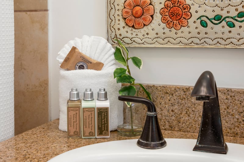 With its colorful, folk-inspired mirror and rich bronze hardware, this bathroom offers a truly unique bathing retreat