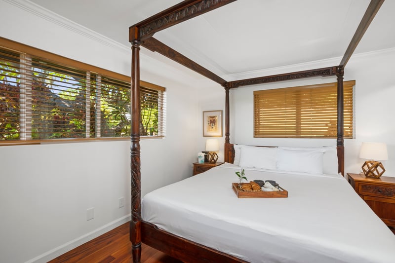 Fall asleep beneath the hand-carved canopy of this dreamy four-poster bed while golden sunlight filters through blinds