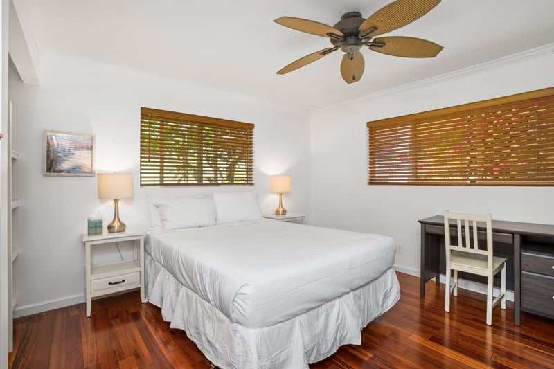 Golden blinds filter soft morning light, while white linens and natural textures invite you to linger and unwind
