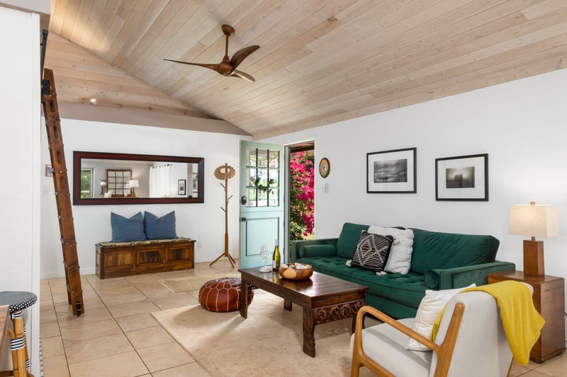This living room feels like a vintage postcard sent from paradise—with warm wood, tropical greens, and island charm