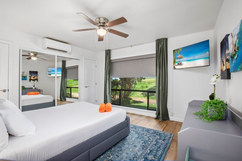 Soft linens, hardwood accents, and island vibes define this bedroom escape