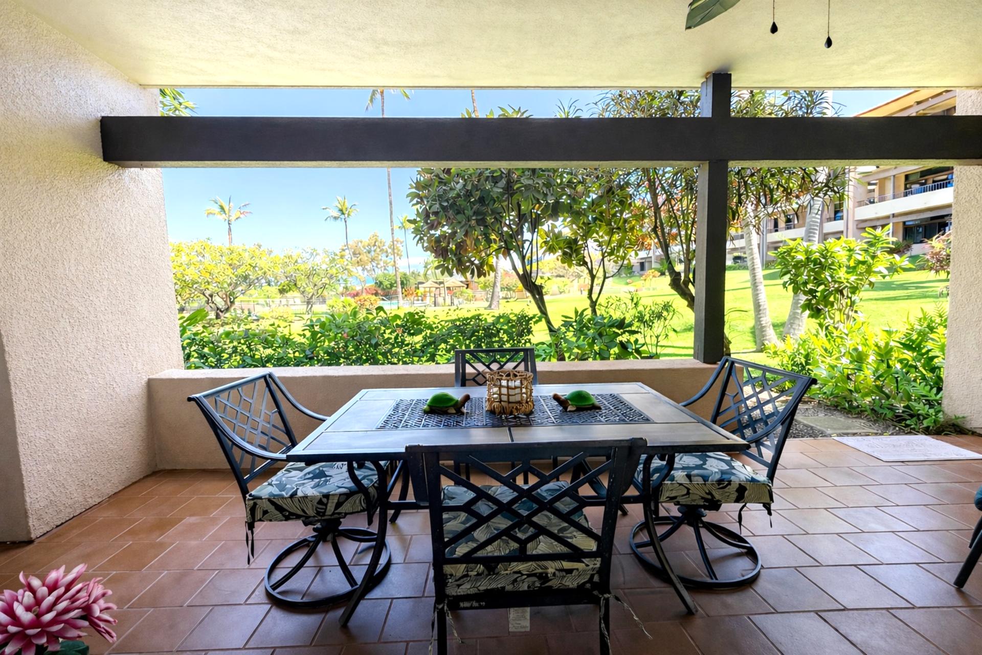 Outdoor dining table surrounded by tropical foliage