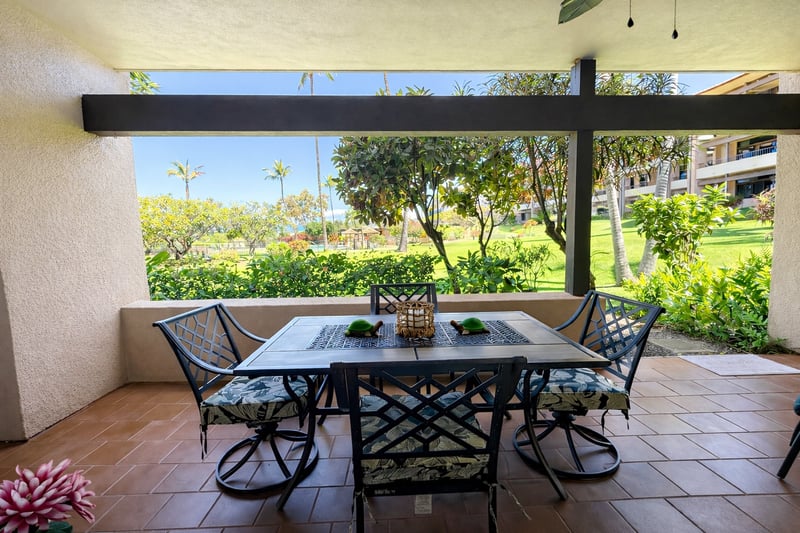 Outdoor dining table surrounded by tropical foliage