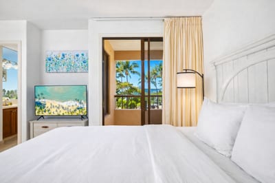 Serene and sun-drenched, this guest room offers crisp whites, a private lanai, vibrant art, and coastal charm