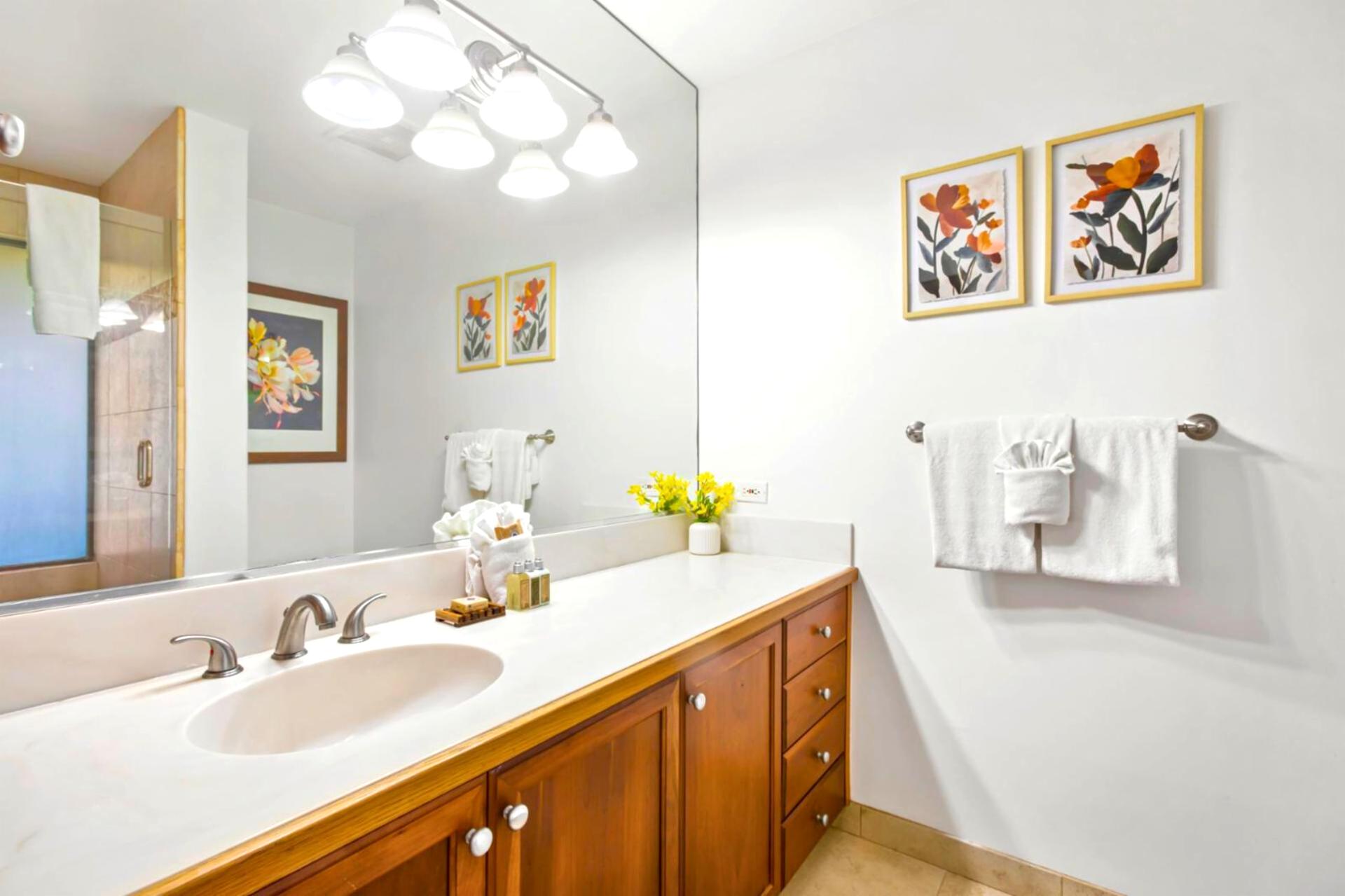 A spacious double vanity in warm wood tones pairs with brushed nickel fixtures, creating a calm and curated guest retreat    