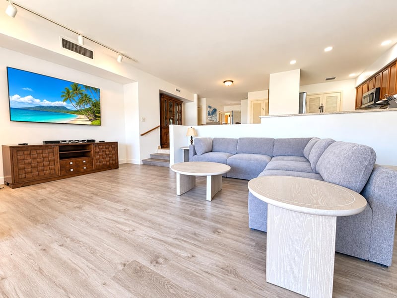 Settle in facing a big TV above a woven-front wood console, with the sectional set for movie nights and the dining area close by.