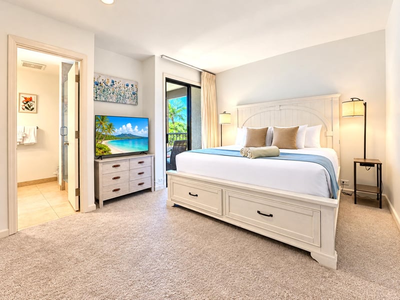Soft carpet underfoot, a storage-drawer bed frame, and a floral canvas above the dresser give your second bedroom an easy coastal feel.