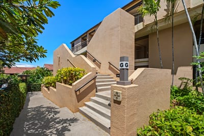 A sunlit stairway framed by lush greens guides you home—where modern charm meets tropical tranquility