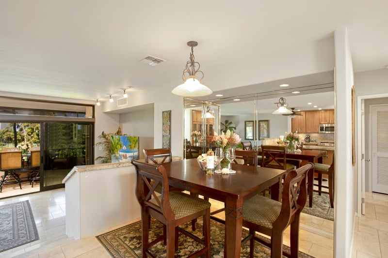 Elegant dining area with mirrored walls and tropical floral centerpiece.