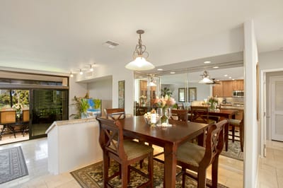 Elegant dining area with mirrored walls and tropical floral centerpiece.
