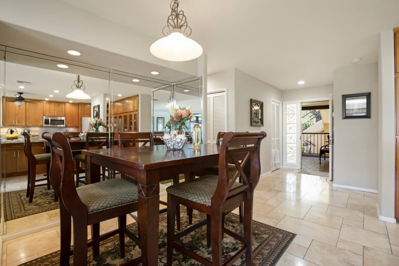 Spacious dining area with mirrored accents and natural tile flooring.