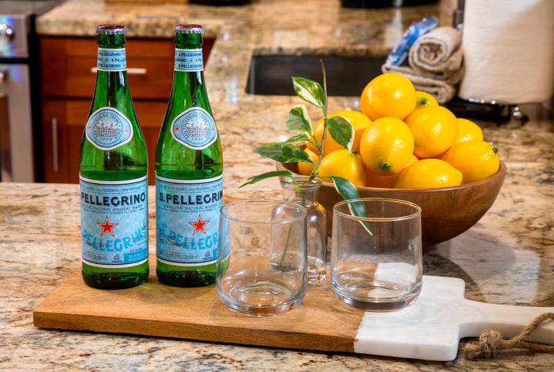 Refreshing welcome with sparkling water, lemons, and elegant glassware setup.
