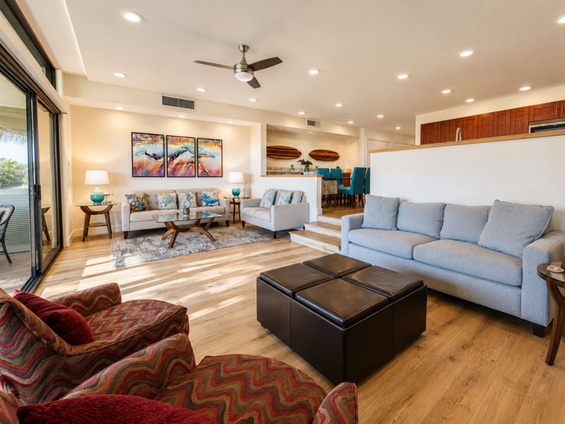 Your living room opens onto a bright dining nook accented by surfboard wall art and a triptych of breaching whales above the sofa.