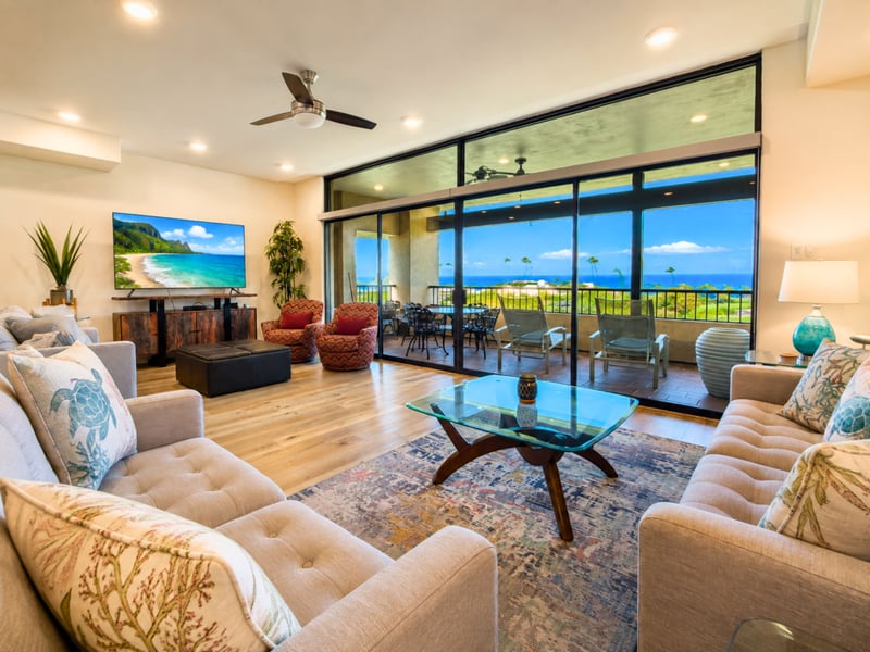 Floor to ceiling sliders connect the open seating area to your private lanai, so indoor and outdoor living flow together.
