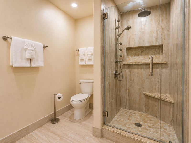 Step into the guest bath's glass walk in shower, with a rainfall showerhead, handheld wand, and a built in tile shelf for your things.