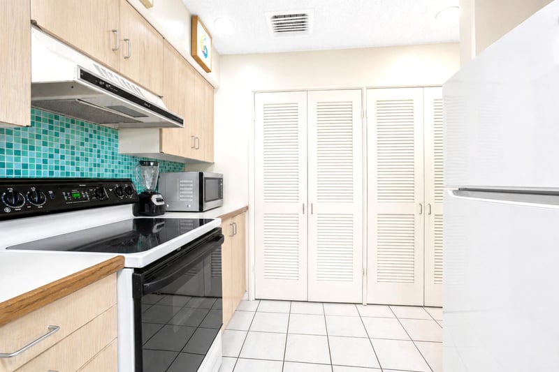 With sea-glass tiles and sandy-hued cabinets, this kitchen feels like a morning walk on the shoreline—refreshing